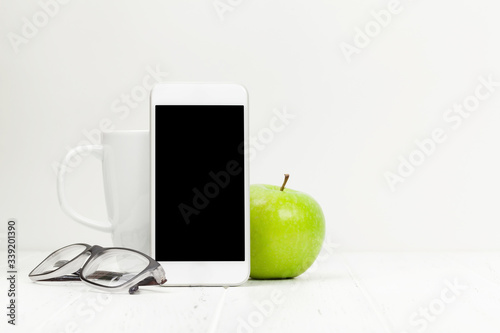 Workplace with smartphone, coffee and apple