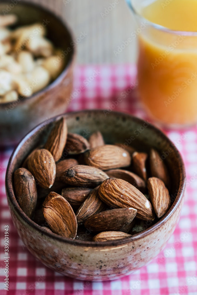 Amandes dans un petit bol pour grignoter à l'apéritif Amandes dans un petit bol pour grignoter à l'apéritif