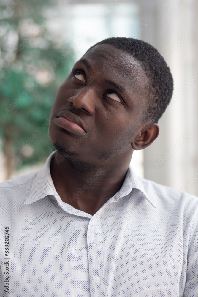 Fototapeta premium Upset African black man looking up; African black man looking with negative feeling, bad emotion, stress, problem