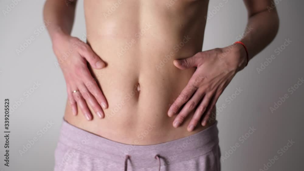 Girl retracts belly raising arms up. Close-up of female belly of sexy girl. White female's fit body and tan skin. Caucasian woman's flat stomach and arms. Weight Loss During Quarantine Girl retracts belly raising arms up. Close-up of female belly of sexy girl. White female's fit body and tan skin. Caucasian woman's flat stomach and arms. Weight Loss During Quarantine