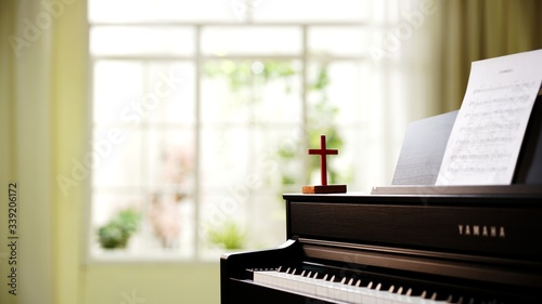 Wooden cross on piano indoor, copy space