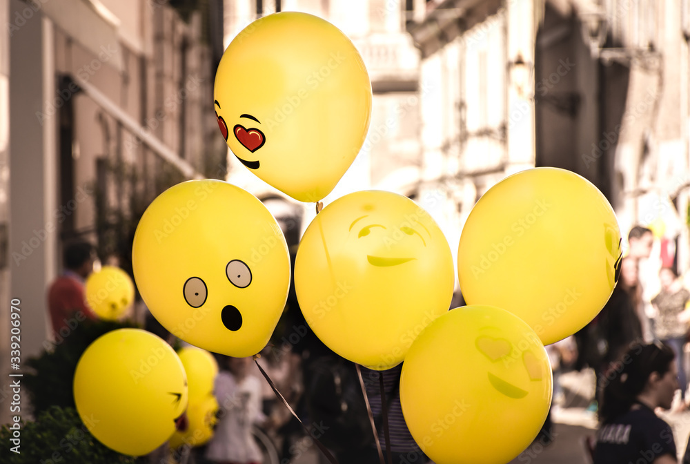 Yellow Emoji balloons floating at a street party in Senigallia, Le Marche, Italy
