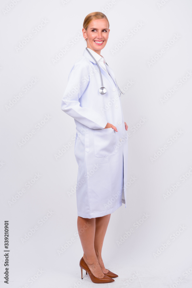 Full body shot of happy blonde woman doctor thinking Full body shot of happy blonde woman doctor thinking