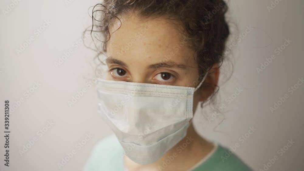 Female nurse or doctor tired and exhausted looks at camera with a serious face