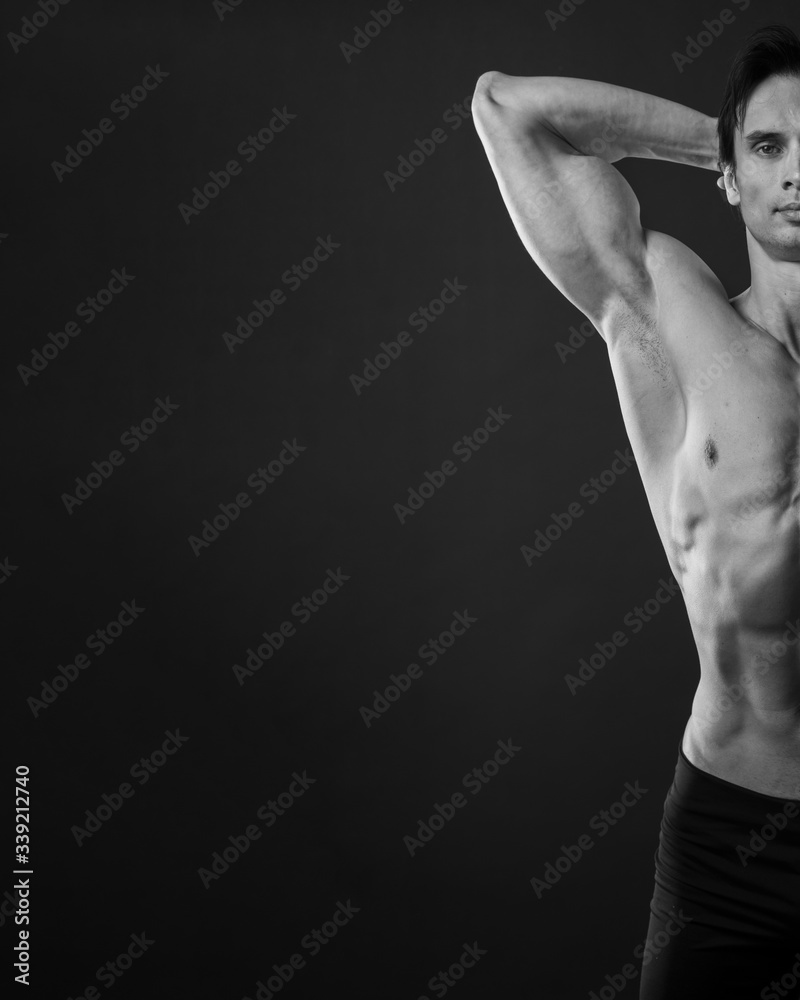 Front view of athletic man showing off biceps in black and white