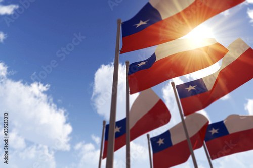 Chile flags waving in the wind against a blue sky. 3D Rendering photo
