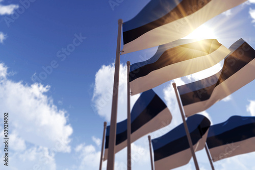 Estonia flags waving in the wind against a blue sky. 3D Rendering