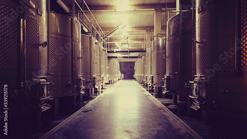 Aisle Amidst Storage Tanks In Brewery
