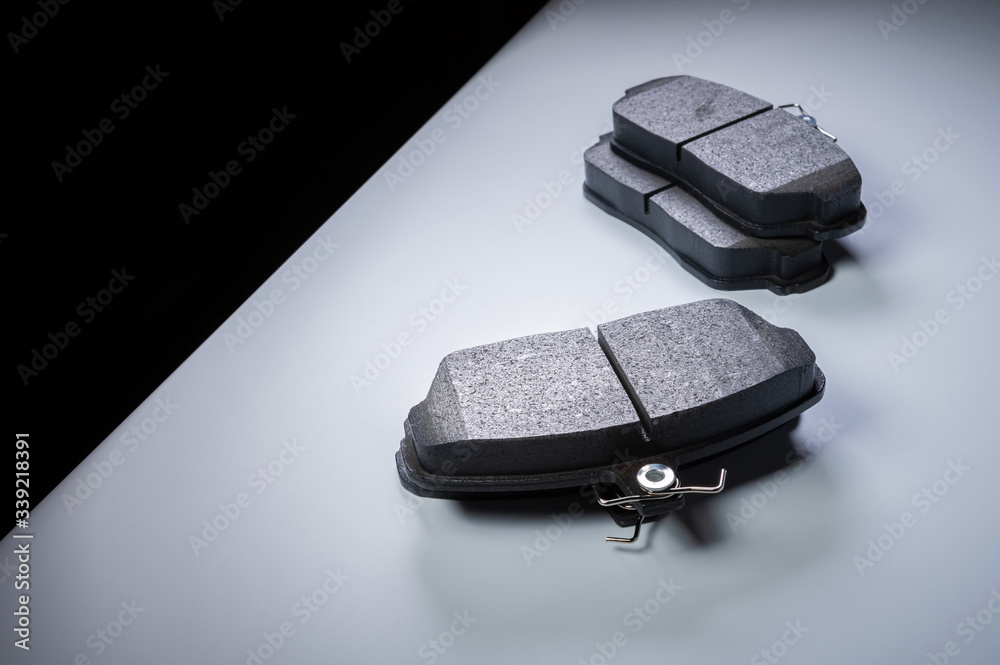 Single wheel kit new brake pads on a gray gradient background. The concept of new spare parts for car suspension Single wheel kit new brake pads on a gray gradient background. The concept of new spare parts for car suspension