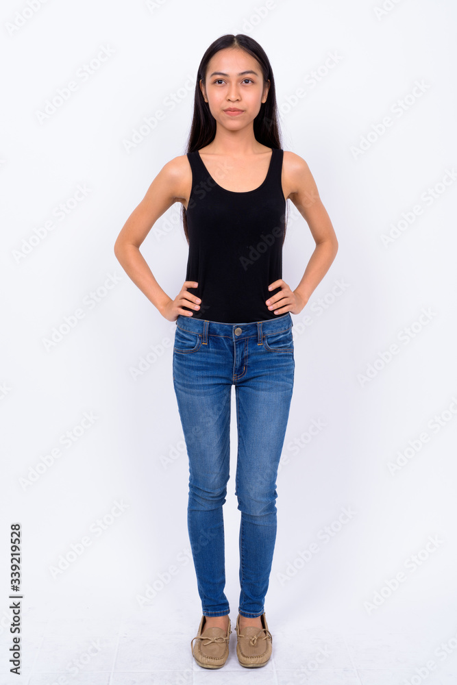 Full body shot of young beautiful Asian woman thinking Full body shot of young beautiful Asian woman thinking