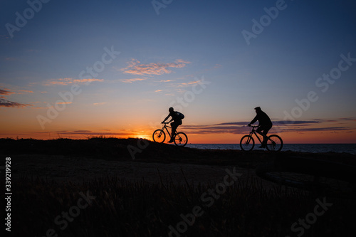 two friends on bikes enjoy a beautiful sunset