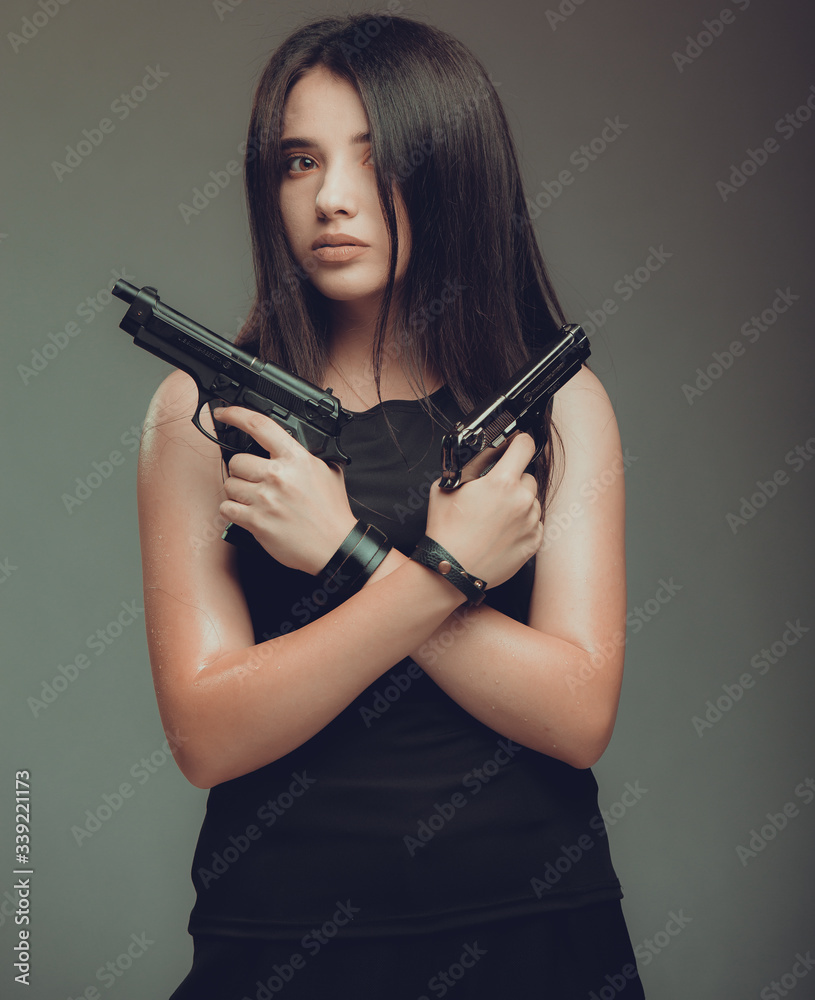 Shot of a sexy military woman posing with guns Shot of a sexy military woman posing with guns