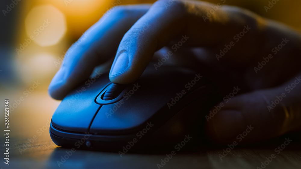 Close-up Macro Shot: Person's Hand Using Wireless Computer Mouse, Scrolls through Apps and Websites with a Wheel and Clicks on Buttons. In the Background Evening Light Close-up Macro Shot: Person's Hand Using Wireless Computer Mouse, Scrolls through Apps and Websites with a Wheel and Clicks on Buttons. In the Background Evening Light