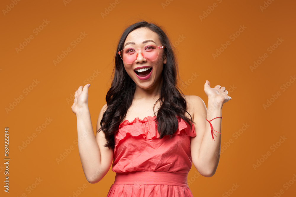 Screaming woman in pink glasses on empty orange background Screaming woman in pink glasses on empty orange background