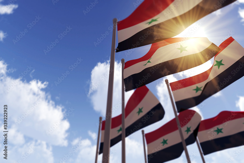Syria flags waving in the wind against a blue sky. 3D Rendering