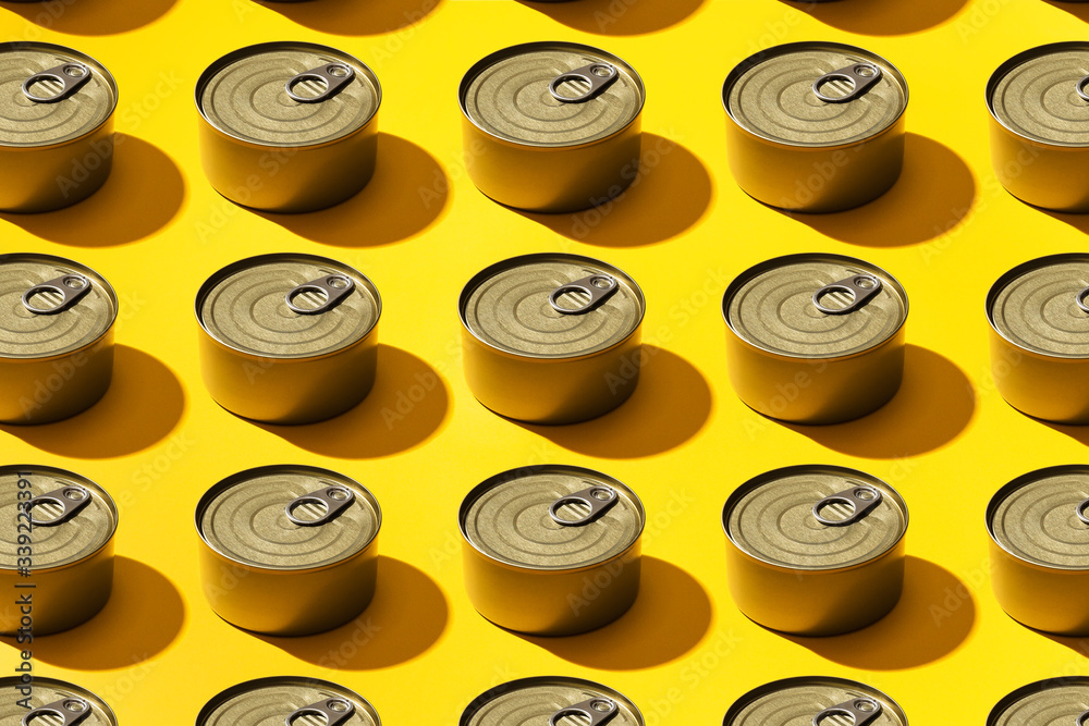 Cans of food laid out inside a pattern, against bright yellow background. Cans of food laid out inside a pattern, against bright yellow background.