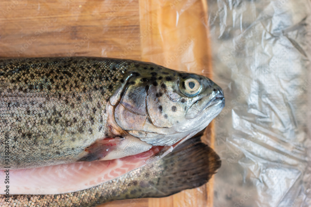 2 Whole rainbow trout fresh from the fishmonger set on transparent foil on the kitchen top 2 Whole rainbow trout fresh from the fishmonger set on transparent foil on the kitchen top