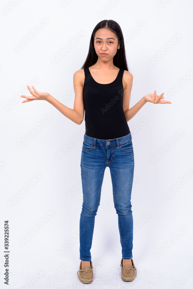 Full body shot of young Asian woman shrugging Full body shot of young Asian woman shrugging