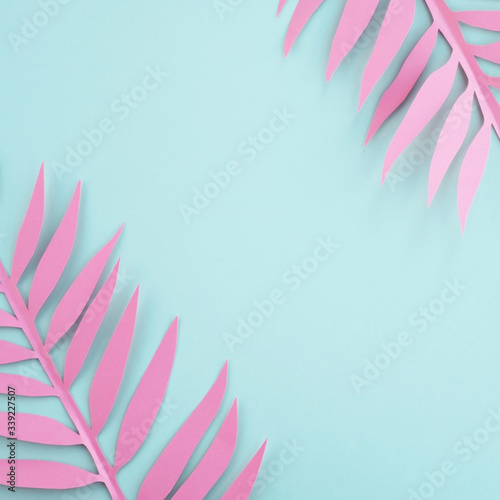 Summer background. Pink paper palm leaves, minimal composition in pastel colors. Top view, flat lay, copy space