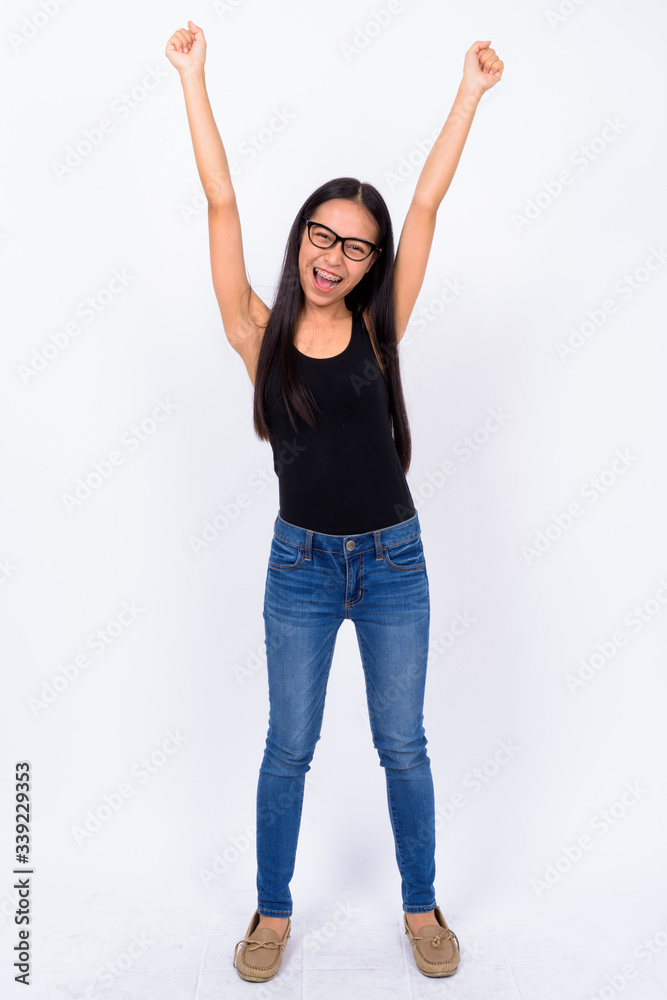 Full body shot of young Asian nerd woman with fists raised Full body shot of young Asian nerd woman with fists raised