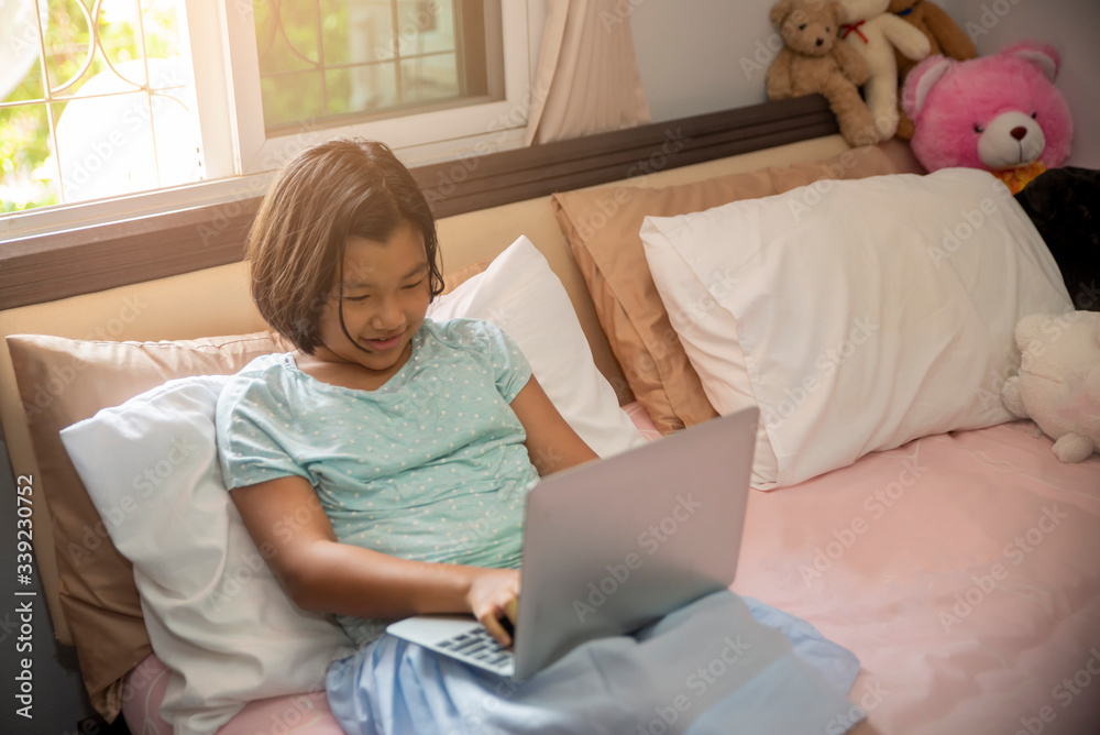 Asian children using laptop to learning and doing homework at home.Happy Thai Students study online for study to the exam.Education concept. Asian children using laptop to learning and doing homework at home.Happy Thai Students study online for study to the exam.Education concept.