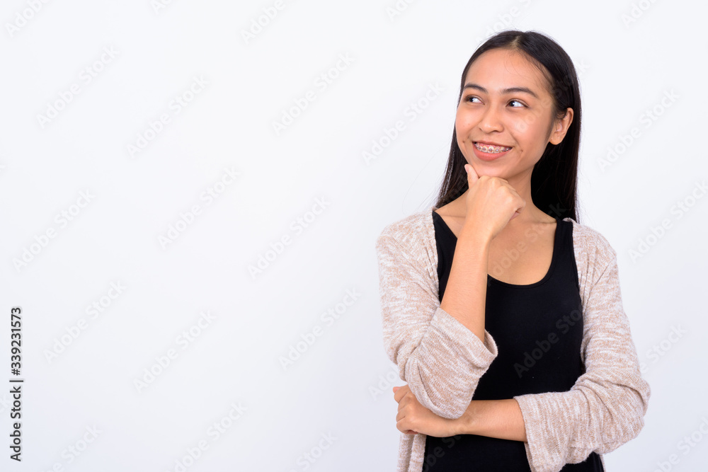 Portrait of happy young beautiful Asian woman thinking Portrait of happy young beautiful Asian woman thinking
