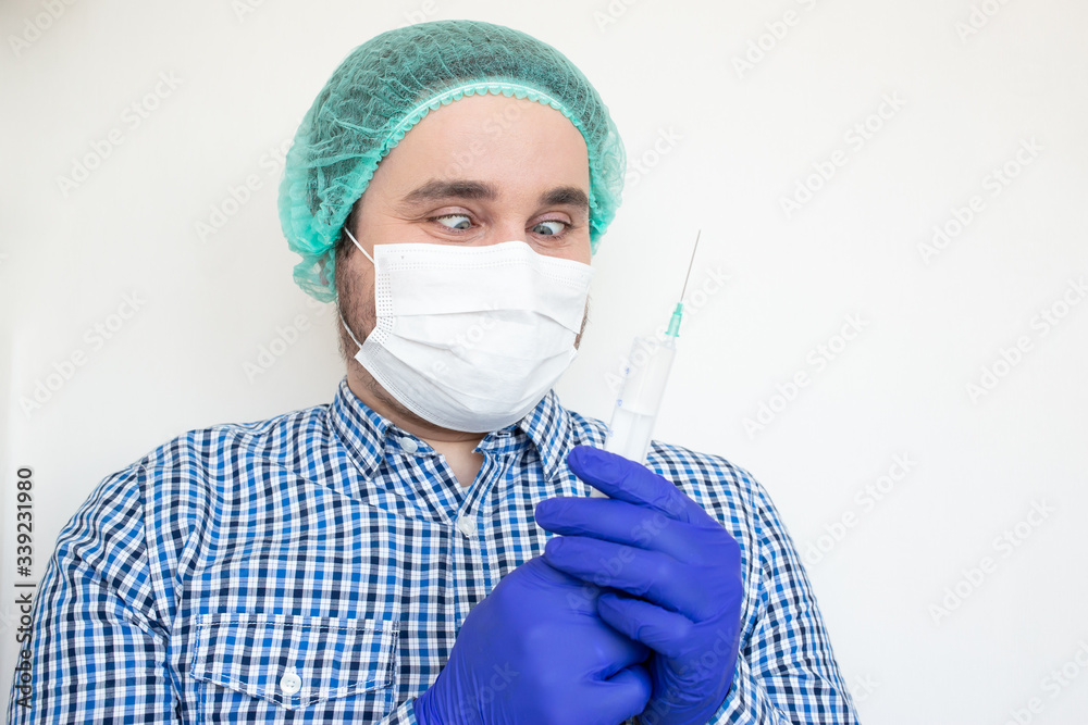 Doctor in mask isolated on white background holds an injection syringe and vaccine. Vaccine from, flu, coronavirus, ebola.