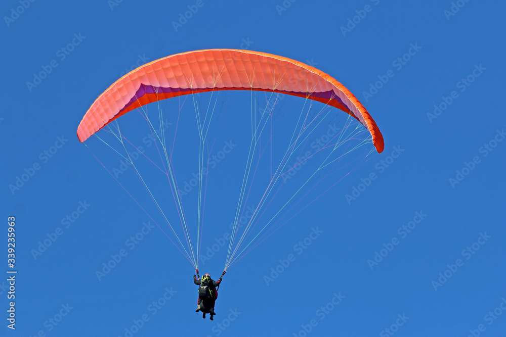Paraglider flying wing in a blue sky Paraglider flying wing in a blue sky