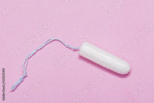 Medical white tampon on pink background, hygienic cotton tampon for women