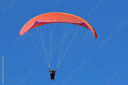 Paraglider flying wing in a blue sky 