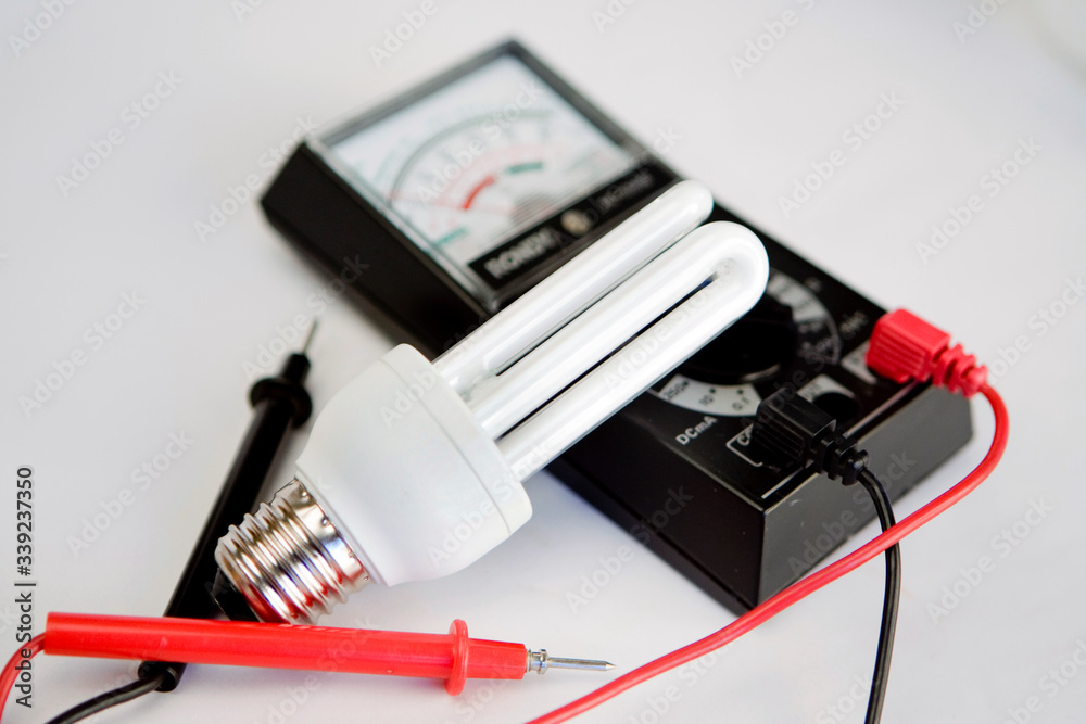 Ampoules led et a incandescence, voltmetre sur fond blanc Ampoules led et a incandescence, voltmetre sur fond blanc