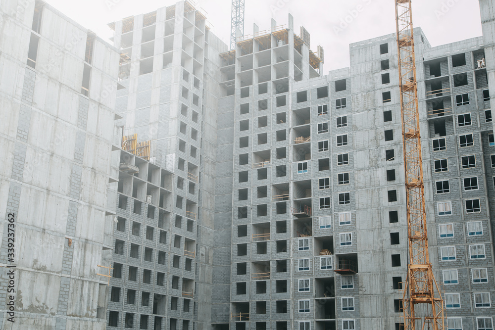  Cranes in the construction of high-rise buildings. Construction of floor coverings. Construction of a building made of solid concrete.