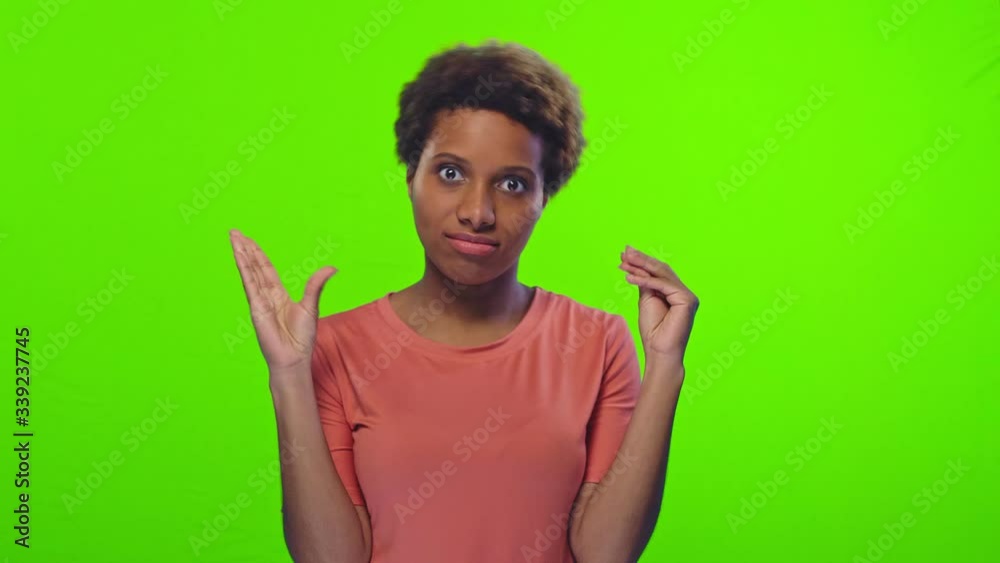 A young dark skinned woman doesn't want to listen anymore and shows blah blah gesture hands symbol of speaking mouth, poses against chromakey background. People, beauty and hand gesture concept