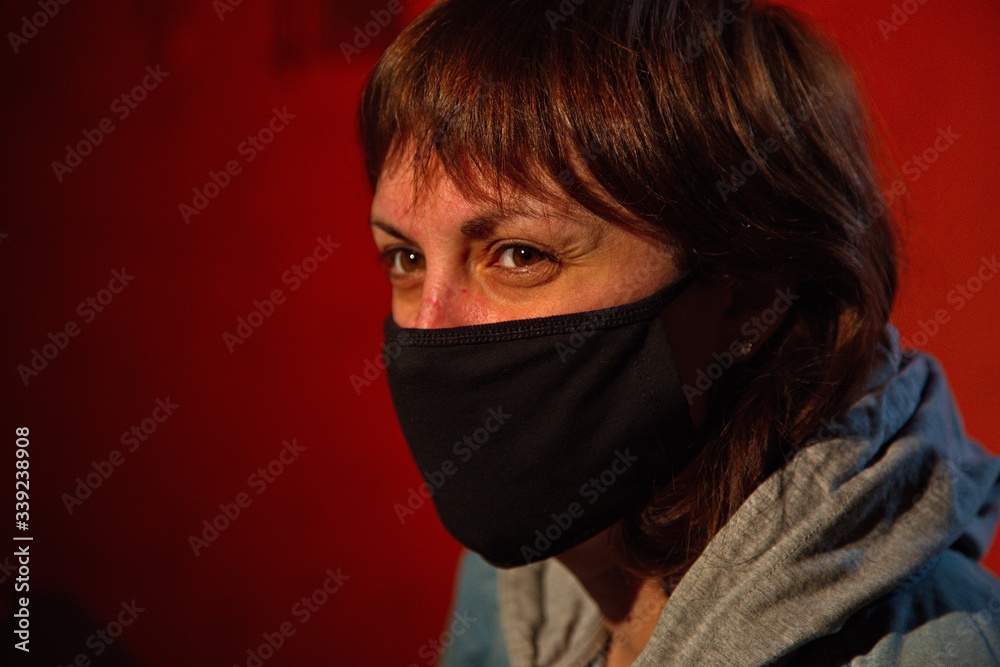 Portrait of a young woman in a black medical mask.