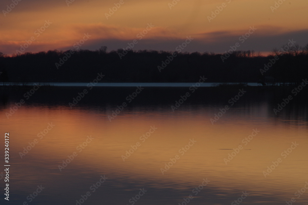 sunset orange and fiery with reflection in lake