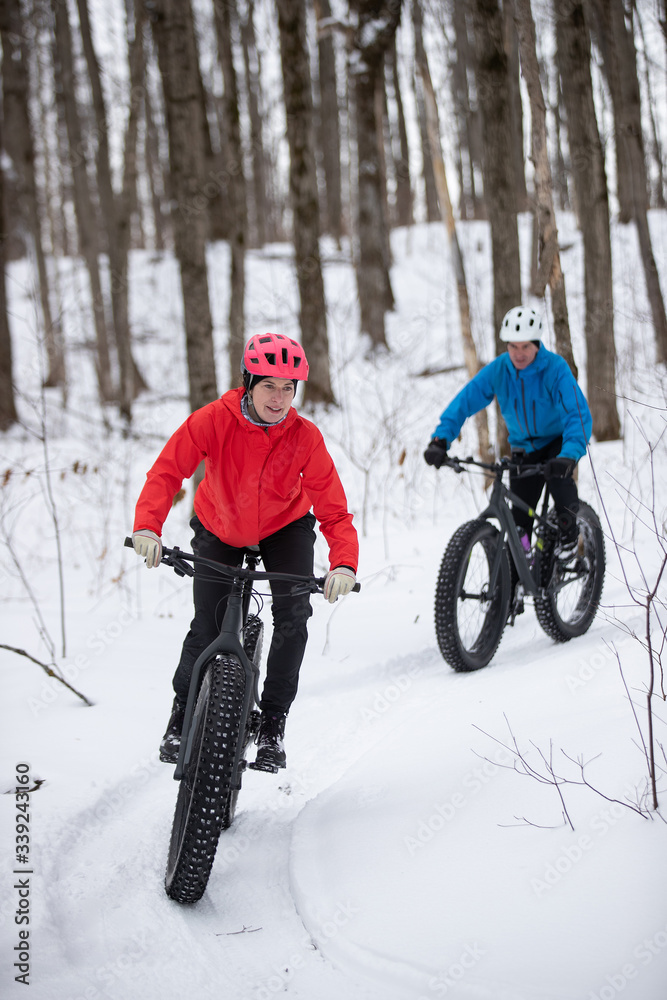Attractive couple riding fat bikes in the snow