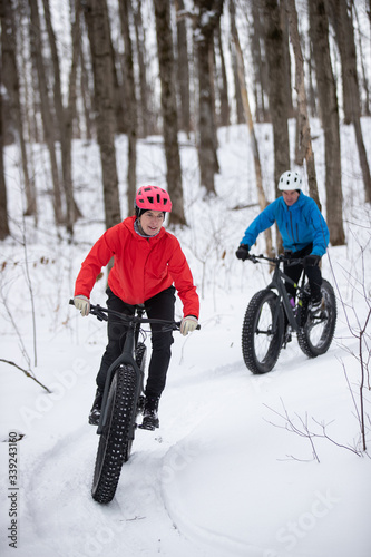Obraz na płótnie Attractive couple riding fat bikes in the snow w salonie