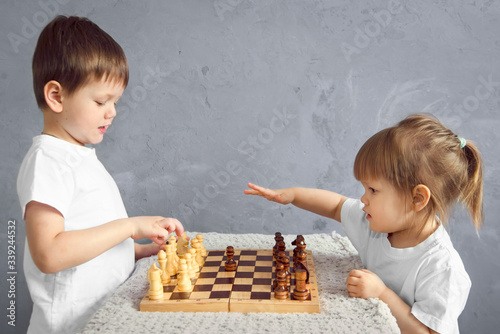 the boy and a little girl plays chess while in his room in self-isolation mode