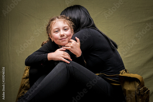 фотографія A woman and a child are hiding in a military shelter