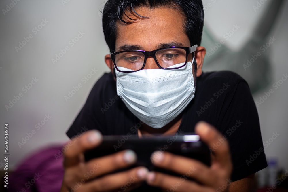 Portrait of a young man playing Mobile video games at Night deu to coronavirus epidemic.