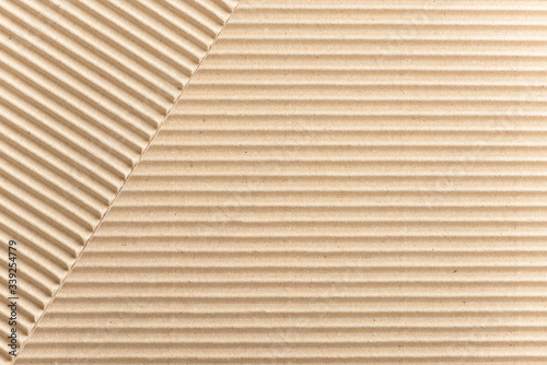 Carton or cardboard packing material. Texture of corrugated paper sheets made from cellulose. Supplies for creating boxes and packaging. Pasteboard background. Natural brown cardboard surface.