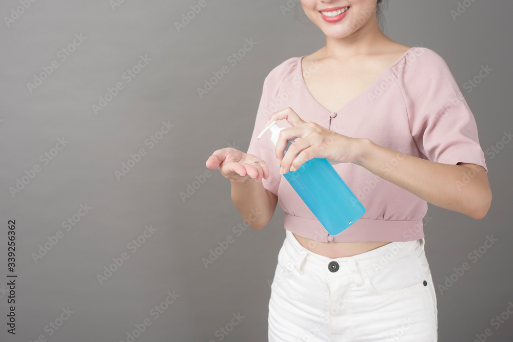 Beautiful woman is using alcohol gel in studio Beautiful woman is using alcohol gel in studio