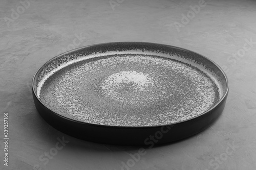 Grey round tray under concrete for placing products.