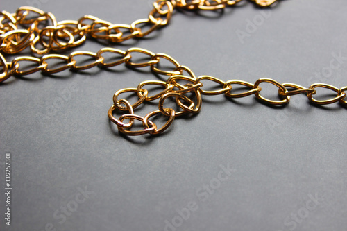 Golden chain with large links on a dark background.