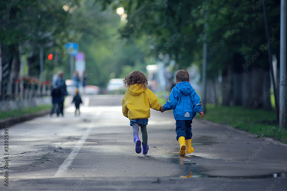 Fototapeta premium children run in raincoats / summer park, rain, walk brother and sister, children boy and girl