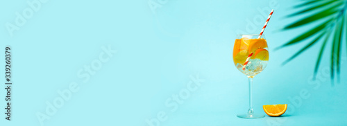 Summer detox drink on a blue background. Summer cold drink with oranges and ice on an empty colored background