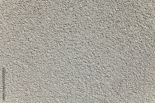Grey wall texture, background. Decor of the cement textured coating. Structural plaster, rough, uneven surface in light grey color. Modern exterior cladding of multi-story buildings