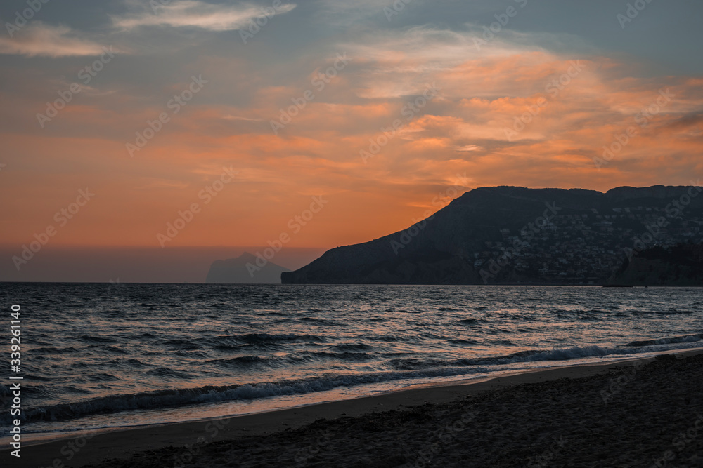 sunset behind the mountain over the sea