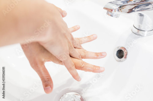 Man washing his hands hygienically under the tap