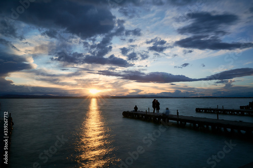 Fototapeta Naklejka Na Ścianę i Meble -  Jetty on a lake a stormy day, sunset
